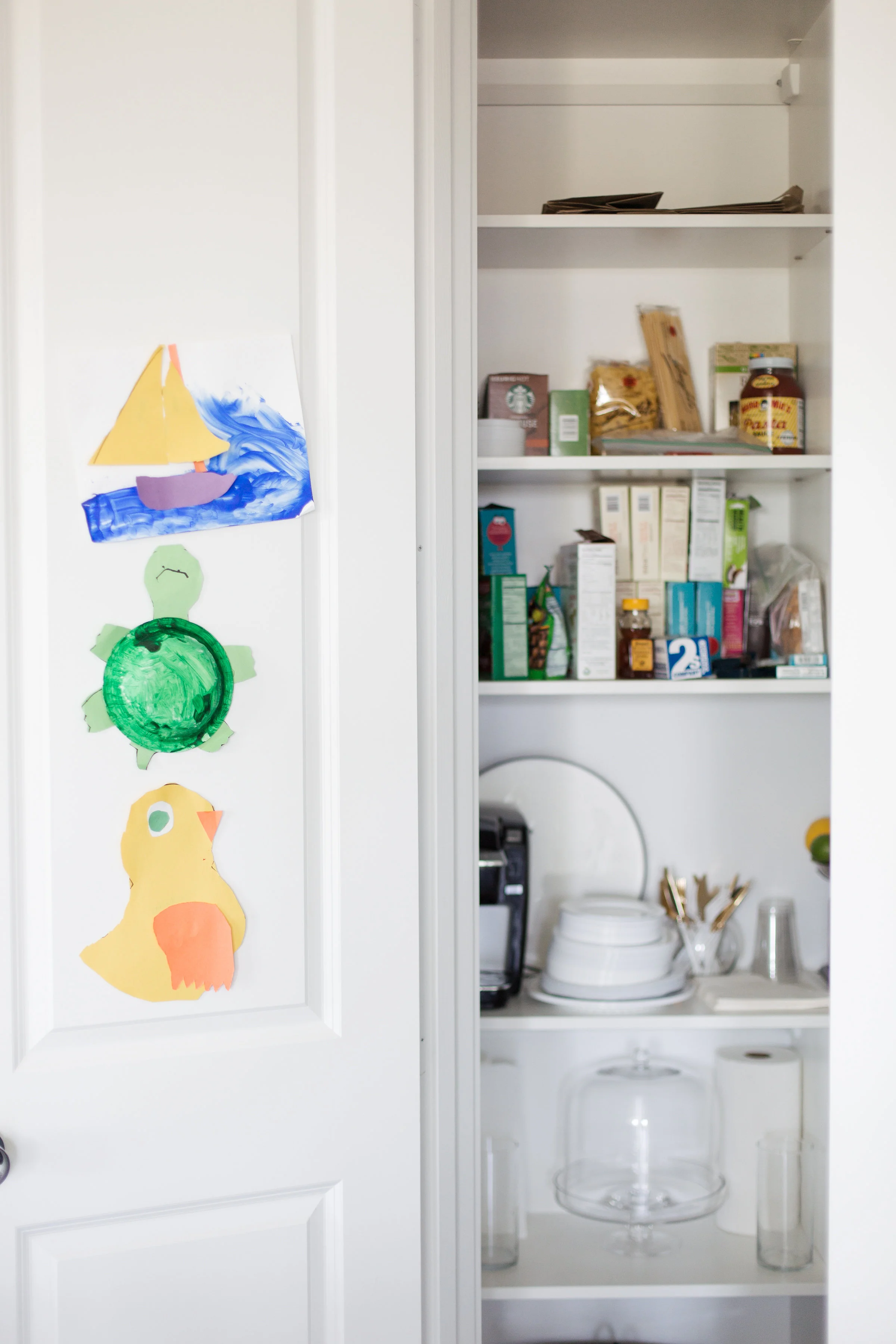 Her son Beck's artwork is a happy welcome into the pantry, which also stores her Keurig, microwave, and toaster.