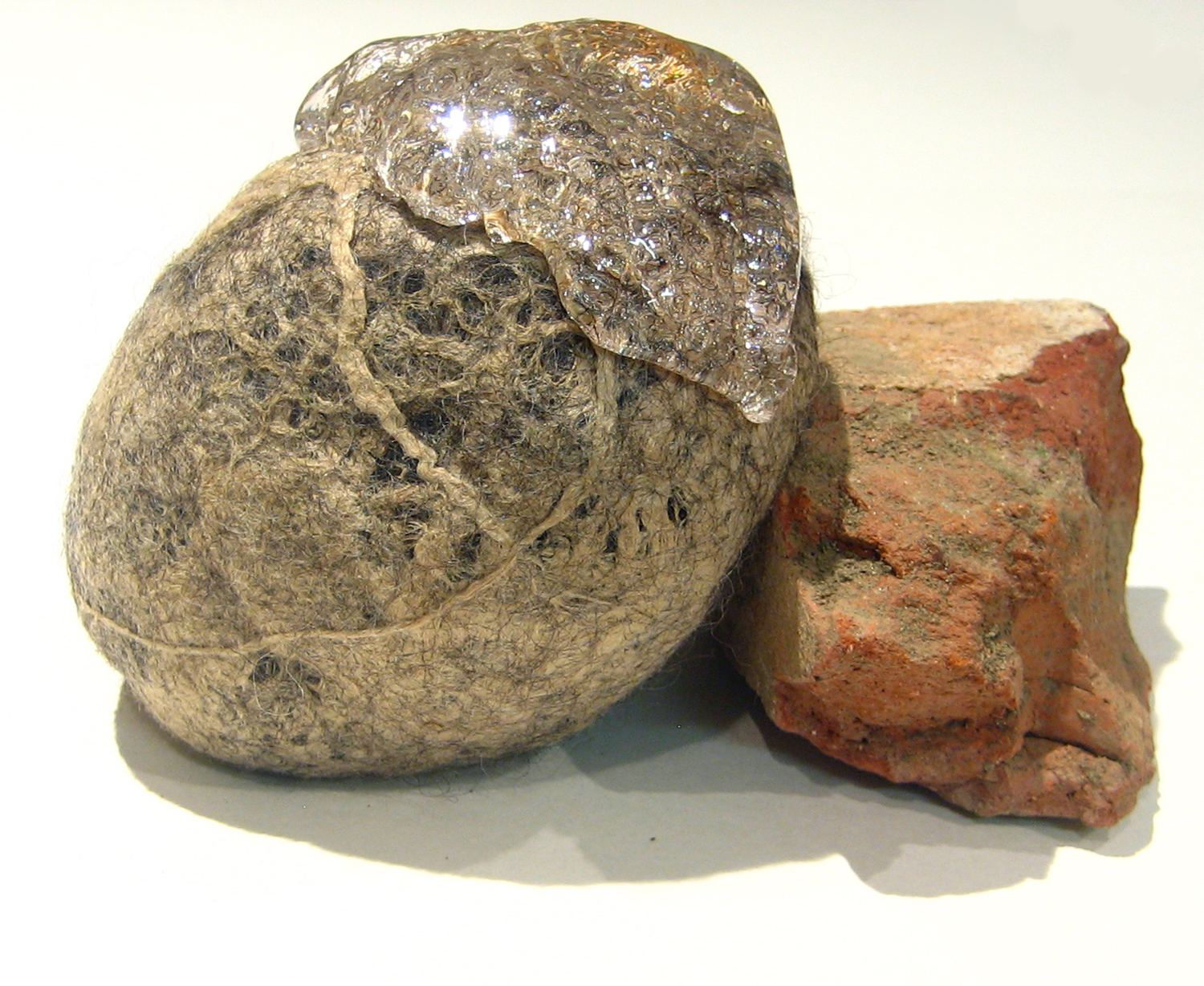 Untitled (Weights holding each other) Hand-felted wool over metal weights, silk, resin, brick 2014