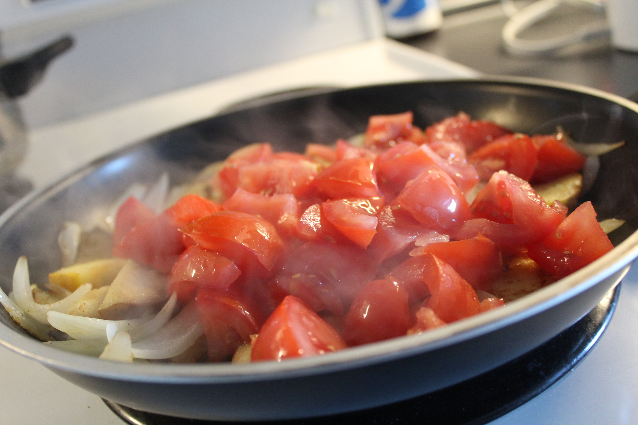Add the tomatoes and leave the low heat to do its magic.  بنضيف البندورة وبنترك النار الهادية تعمل شغلها