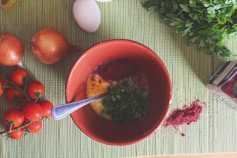 These ingredients are mixed with the eggs rather than added later on. Tons of sumac too. المكونات هاي تخلط مع البيض بدل ما تضاف بعدين. وكتير سماق كمان