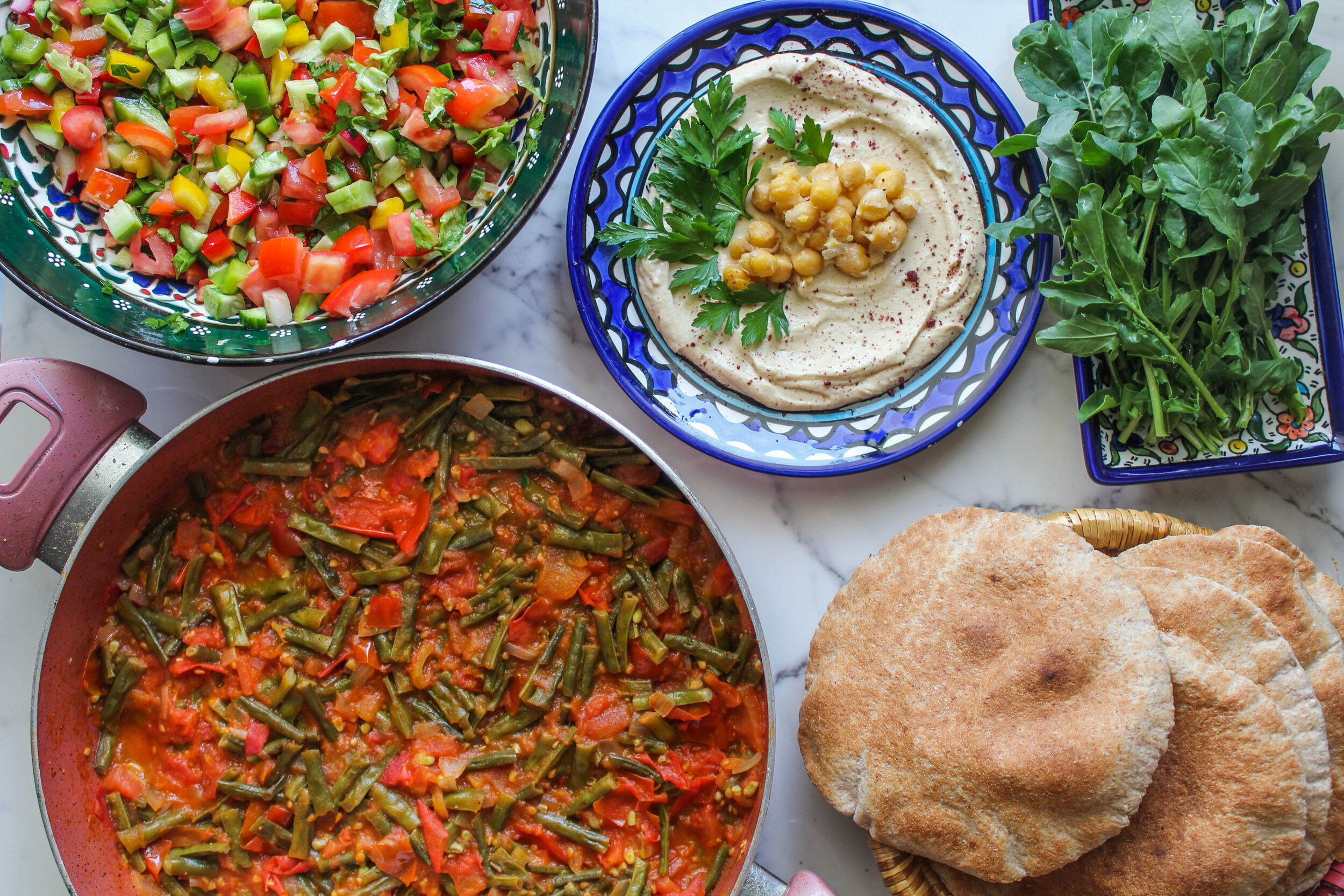  Green bean Allayeh, homemade hummus, whole wheat pita, falahi salad.  قلاية لوبيا بالبندورة، حمص بيتي، خبز كامل القمح، وسلطة فلاحية. 