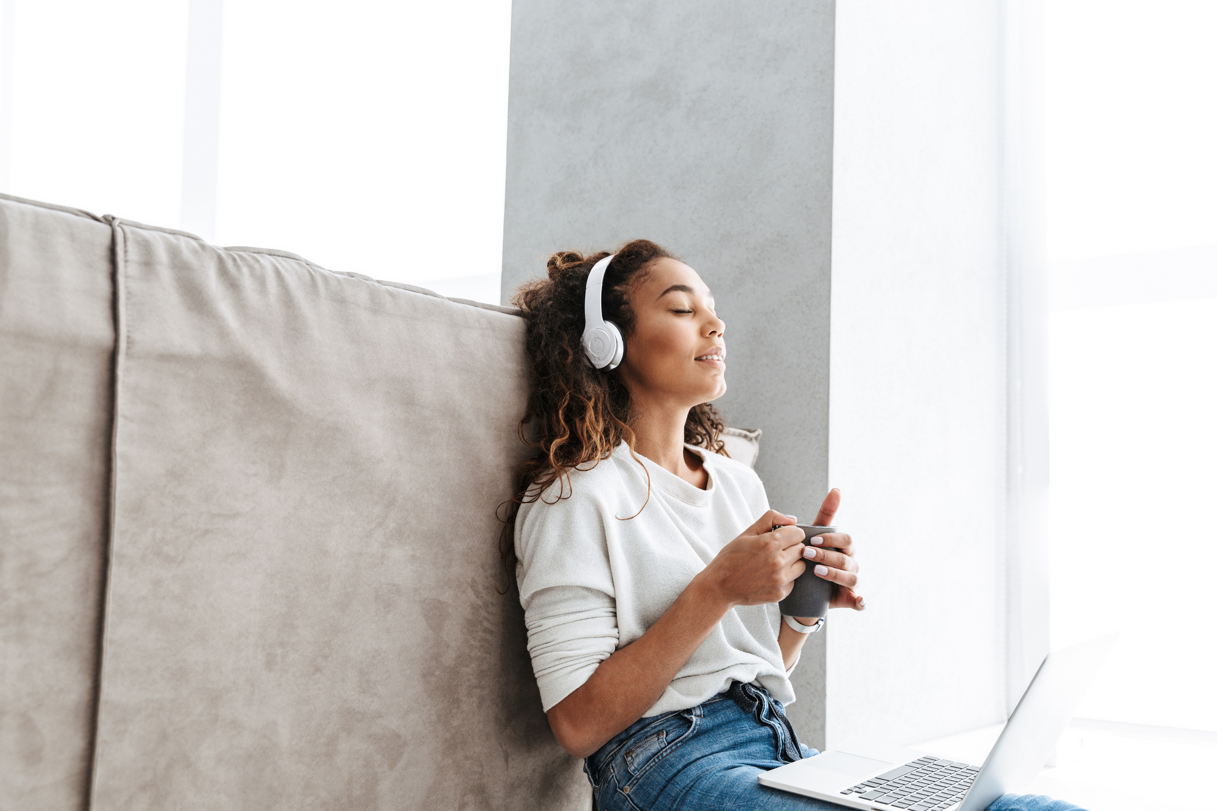 Woman listening to headphones while using computer
