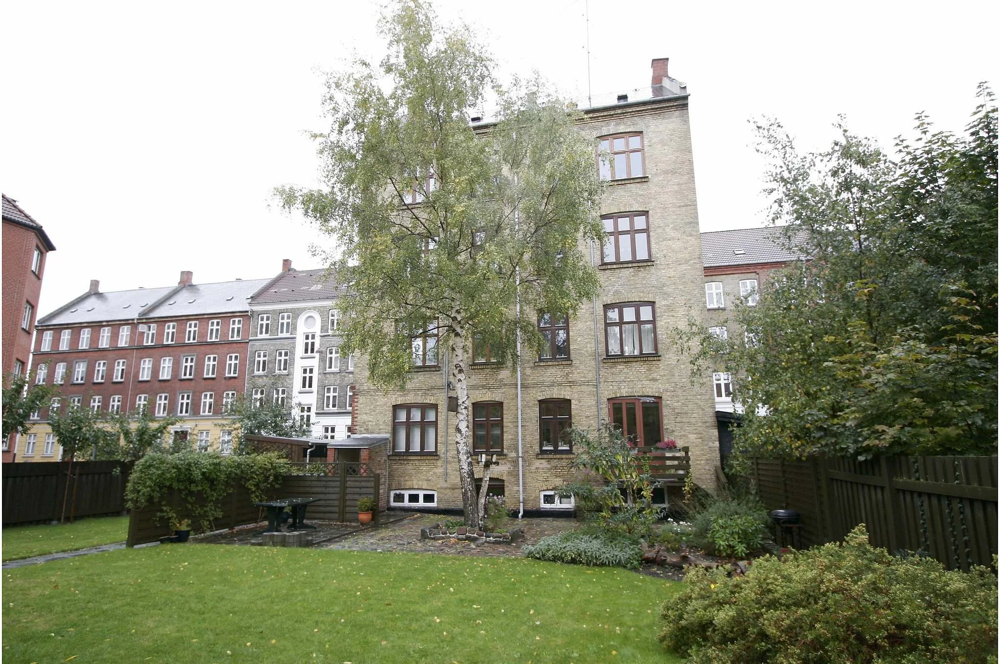 Huset set fra haven Lejligheden er oprindelig en 2-værelses på ca. 45 m2 med et mindre køkken og soveværelse vent mod haven. Stuen mod gaden. Efter ombygning flyttes soveværelse mod gaden og der skabes et stort køkken/opholdsrum mod haven ved nedtagning af væg.