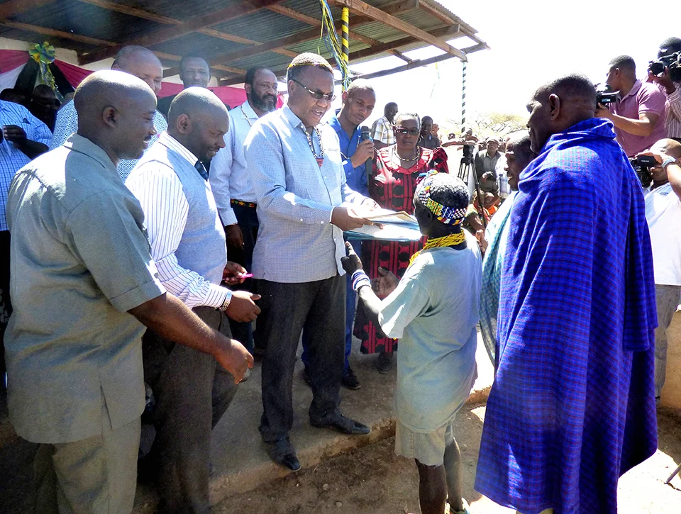 Caption: The Honorable Minister William Lukuvi handing over village land titles and CCROs (Certificate of Customary Right of Occupancy) to the Hadza and Datoga