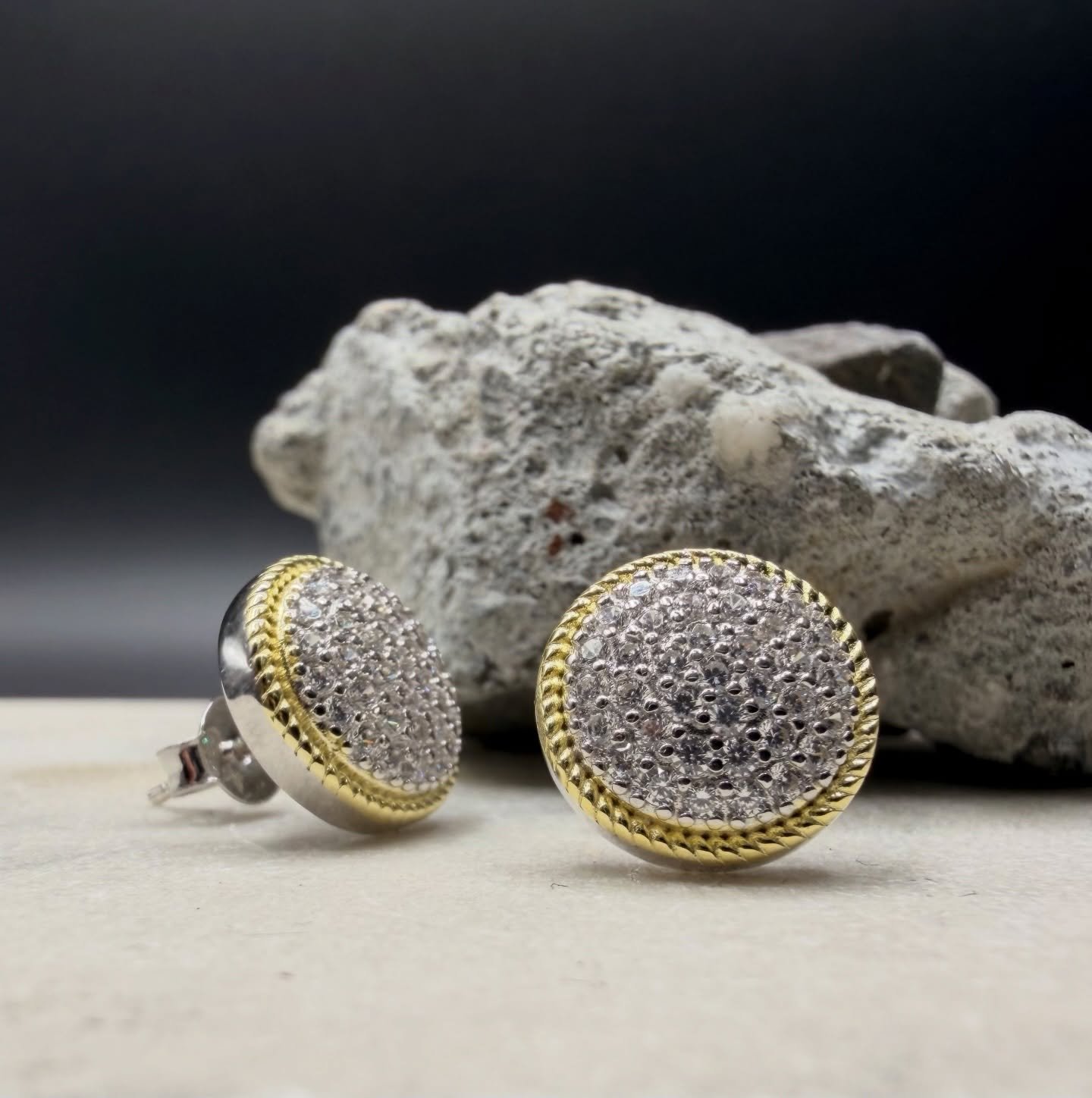 These 925 sterling silver and gold-accent dome studs deliver a clean, timeless shine with a modern edge. Each earring is paved with brilliant cubic stones that create a crisp, diamond-like sparkle, framed by a twisted gold rope border for a touch of 