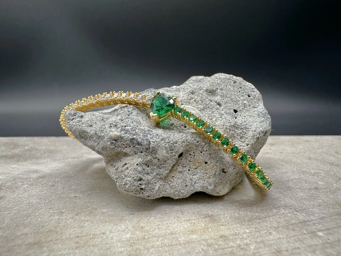 BKB TWO TONE EMERALD BRACELET. 

&bull; Elevate your elegance with the BKB Two Tone Emerald Bracelet, a stunning blend of sophistication and charm. This exquisite tennis bracelet features a captivating heart-shaped emerald at its center, flanked by s