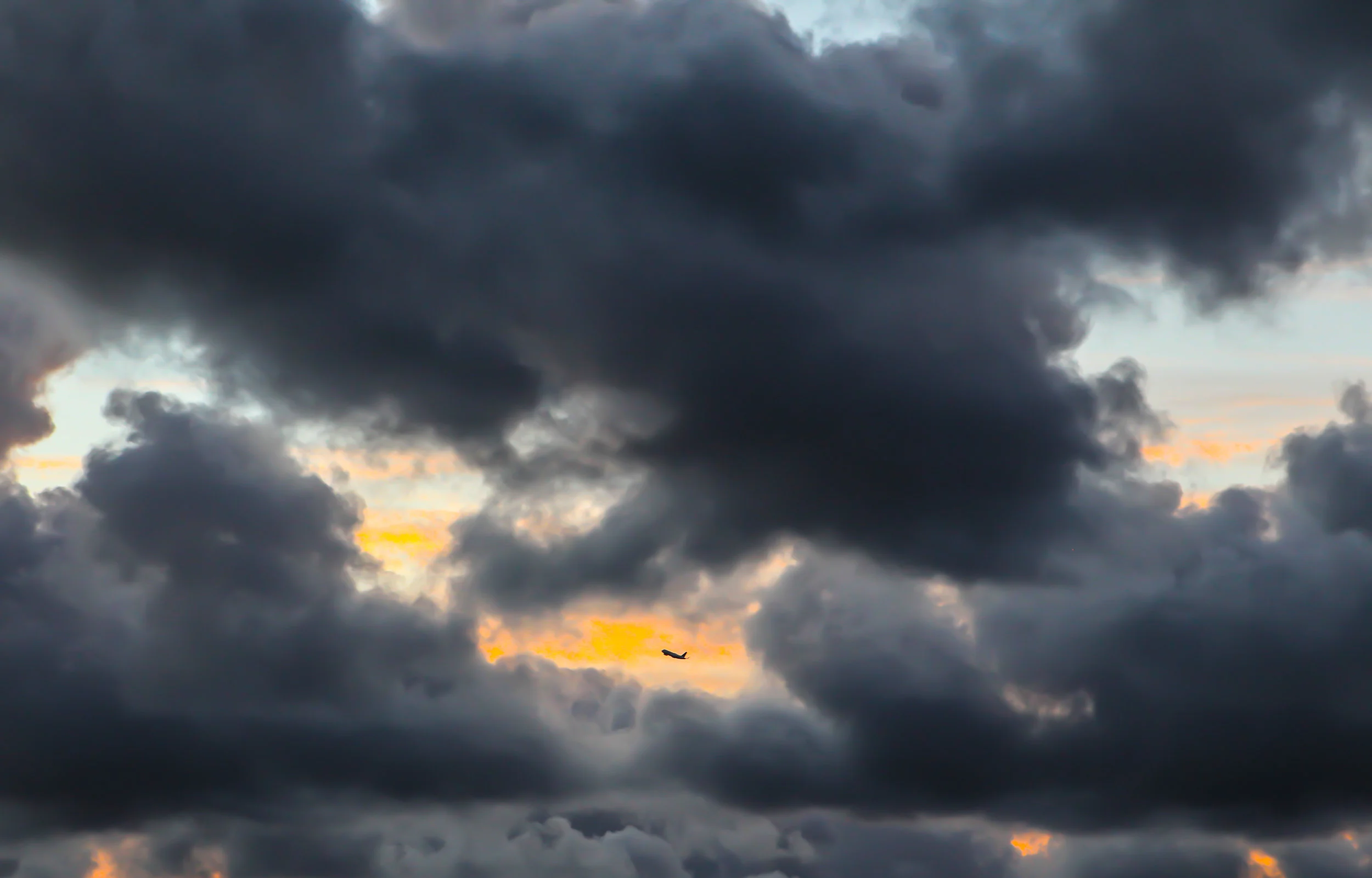  Sunrise with dark clouds ,one plane. Huntington Beach, Ca. 