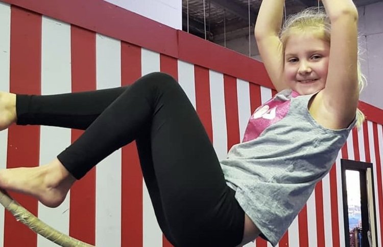 Child smiling on a trapeze