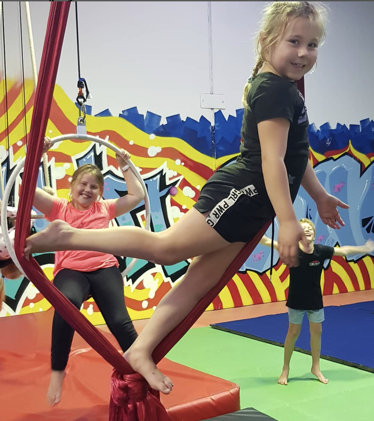 Child on aerial silks in a holiday workshop
