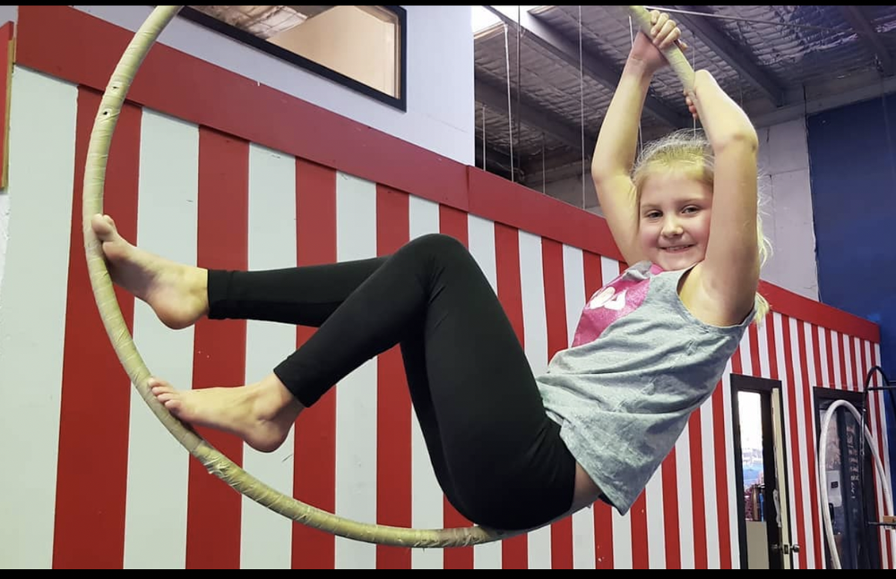 Girl balancing in an aerial hoop at a CircArts party