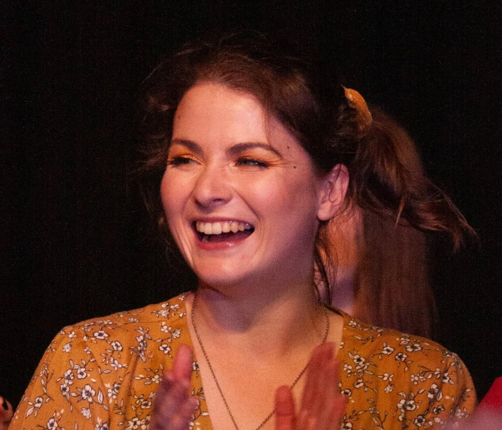 An adult CircArts student laughing with joy at her showcase
