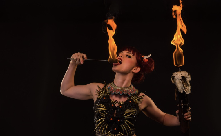 CircArts circus performer with fire torches on stage