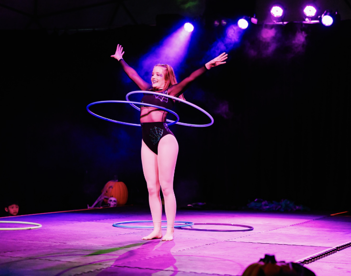 CircArts hula hoop artist spinning multiple hoops on stage