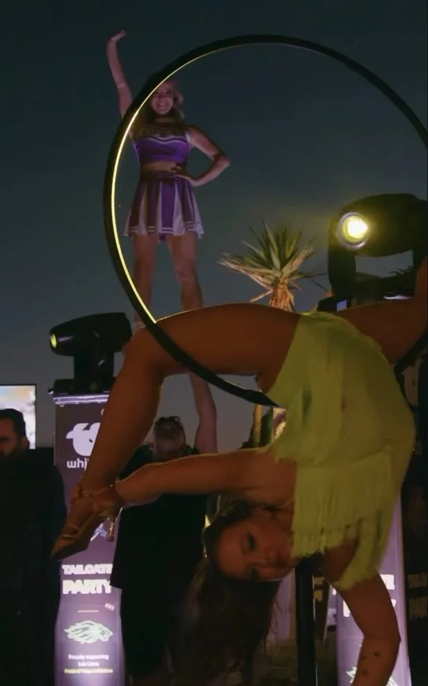 Aerialist performing on a freestanding lollipop lyra hoop at an outdoor party