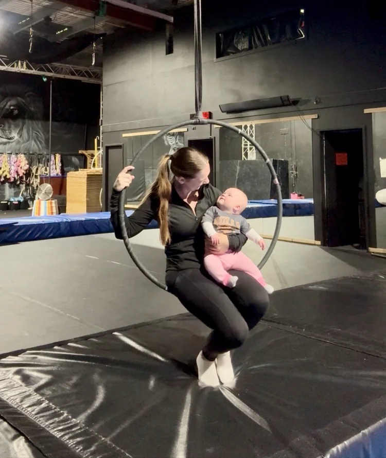 Parent and baby on a lyra in Tiny Circus