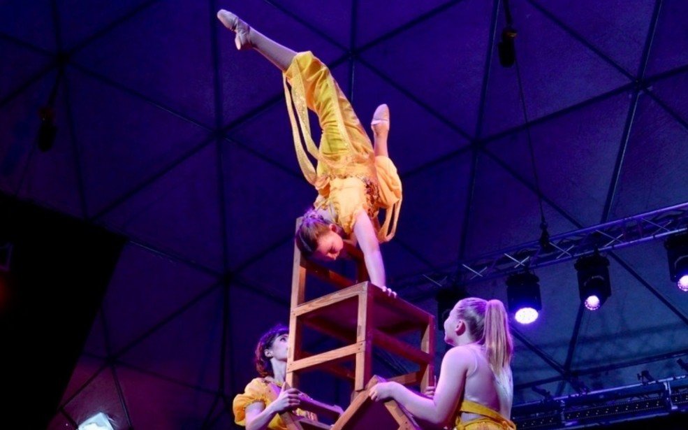 CircArts teen acrobats performing a handstand on a stack of chairs