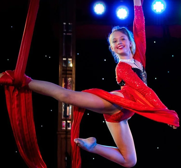 Young aerialist in red on aerial silks