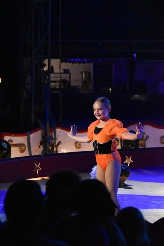 Smiling girl with hula hoops on stage