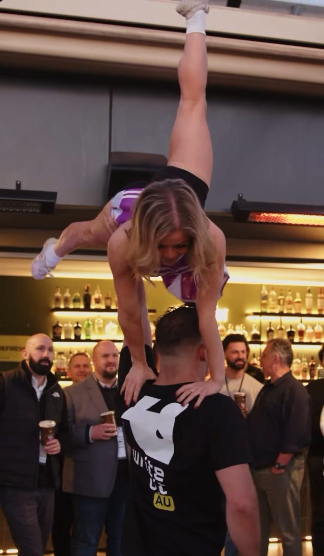 Two CircArts acrobats performing a hand-to-hand balance at a bar event