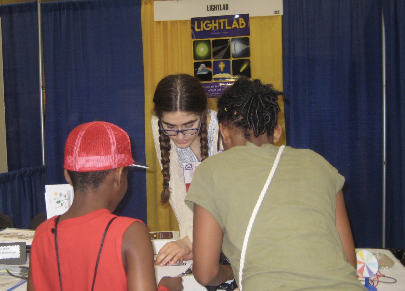 Miriam assisting two attendants at CHAP (Christian Homeschool Association of PA).