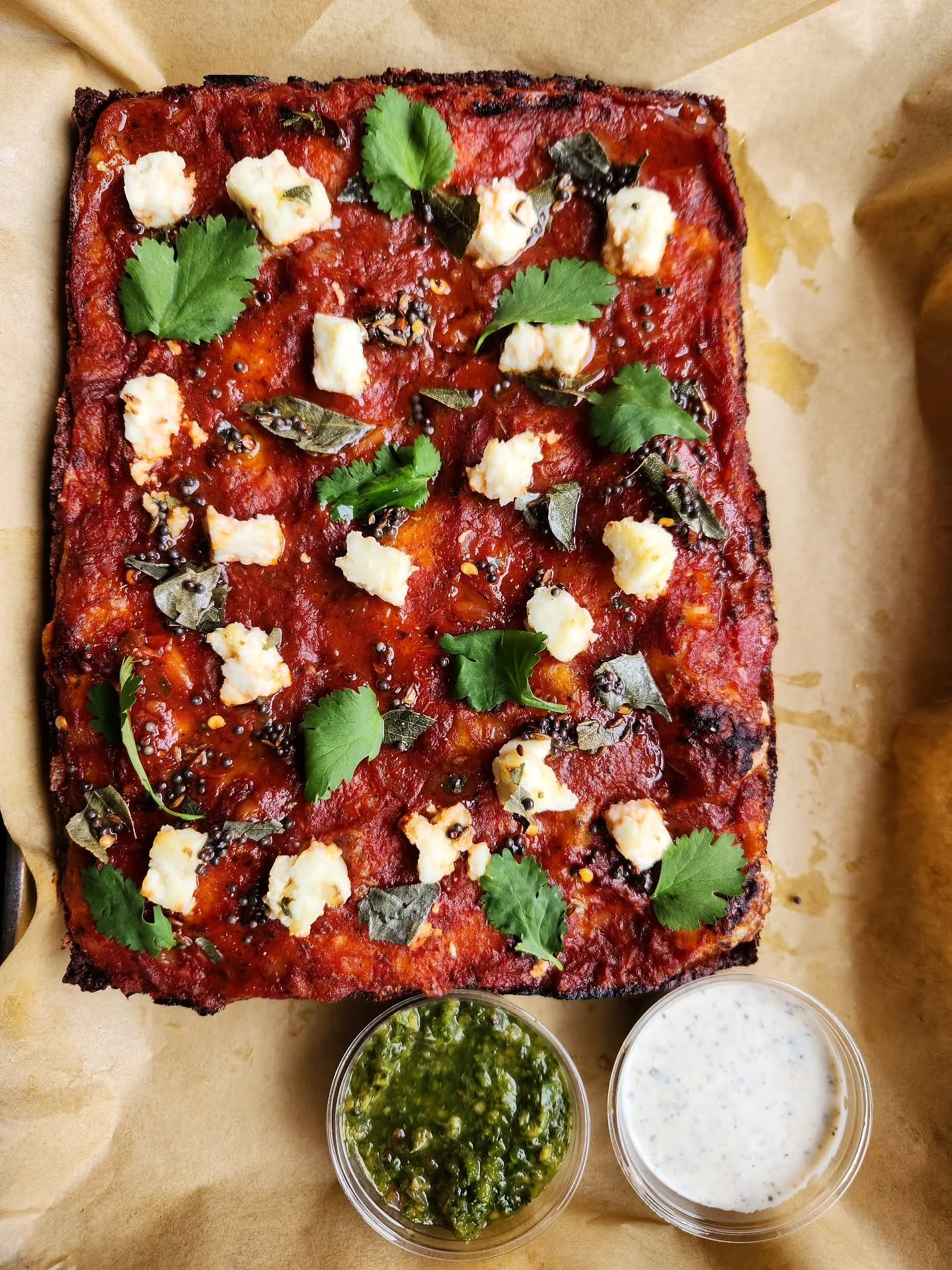 This week's feature has a garam masala spiked tomato sauce, homemade paneer, curry leaf tadka topped with cilantro. Comes with a side of long pepper ranch and green chutney.

Crispy speck and potato feature still on.

Vodka sauce, pepperoni, burrata,