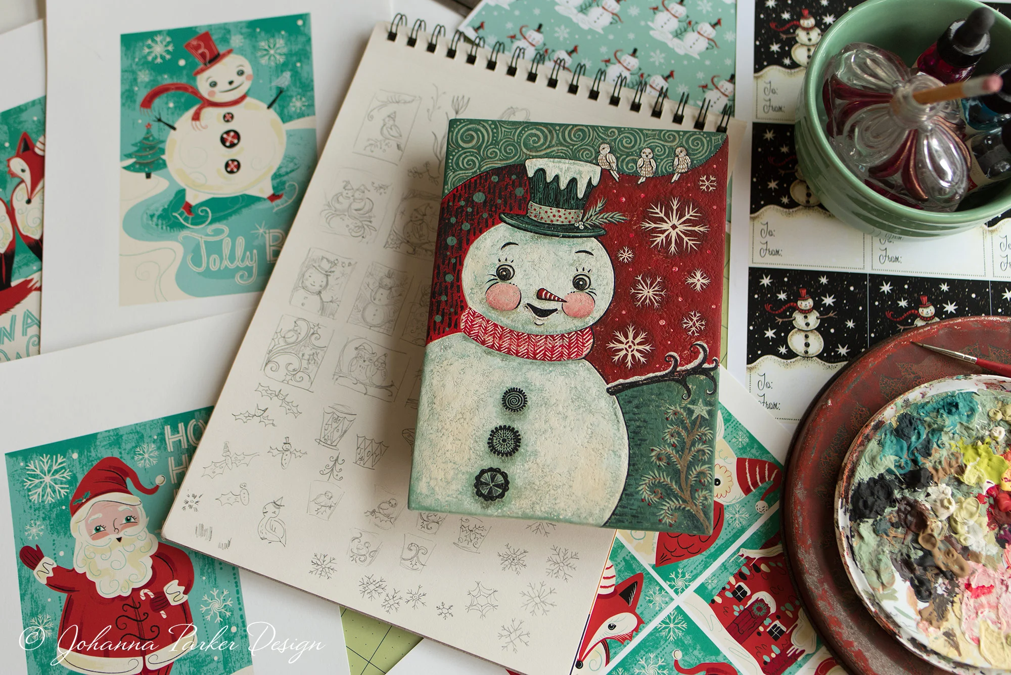 This vignette shows a snapshot of various holiday art projects all grouped together. It's a fun mix of my printed graphics, rough pencil sketches, a painted art panel, pattern repeats and illustrated gift tags ~ All a variety of designs that I could easily delve into on any given day!