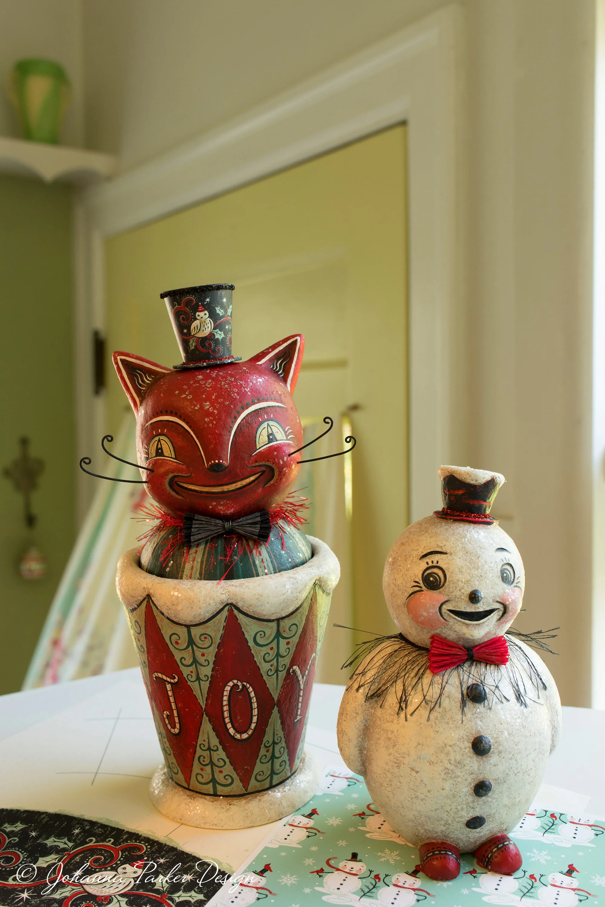 We chose this mischievous pair of holiday folk art characters, a rare, grinning red cat candy container and a standing snowman, to accompany me in my portrait.