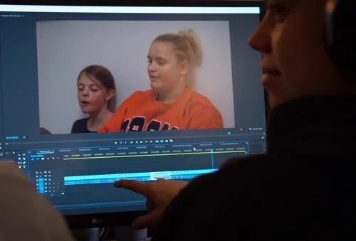 Kursist på filmskole doxworld redigerer film i premiere pro.webp