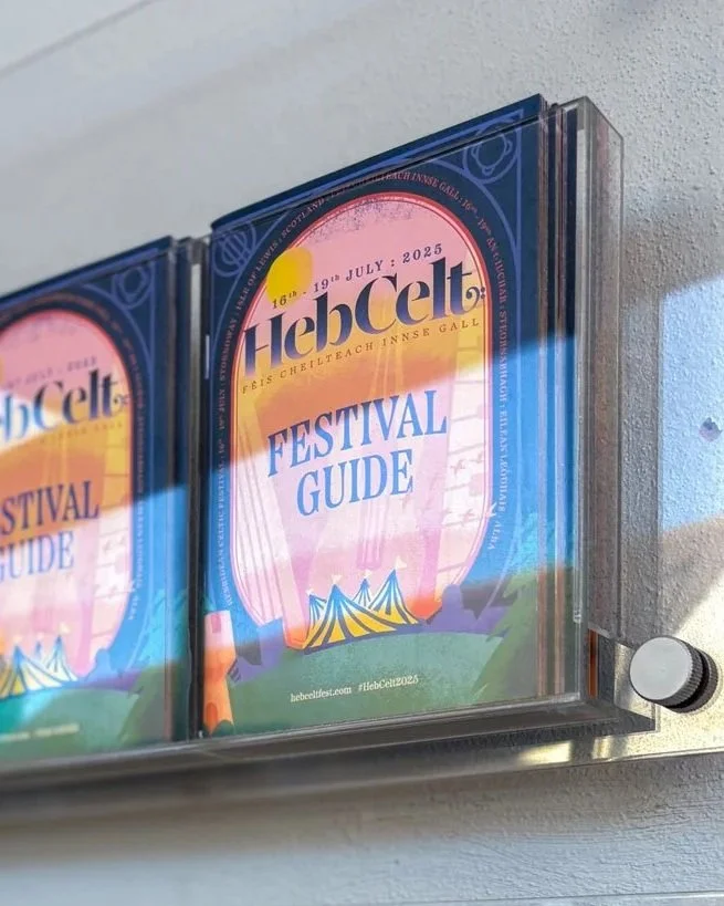 Festival guide for HebCelt 2025 with a colorful sunset and festival tents on cover.