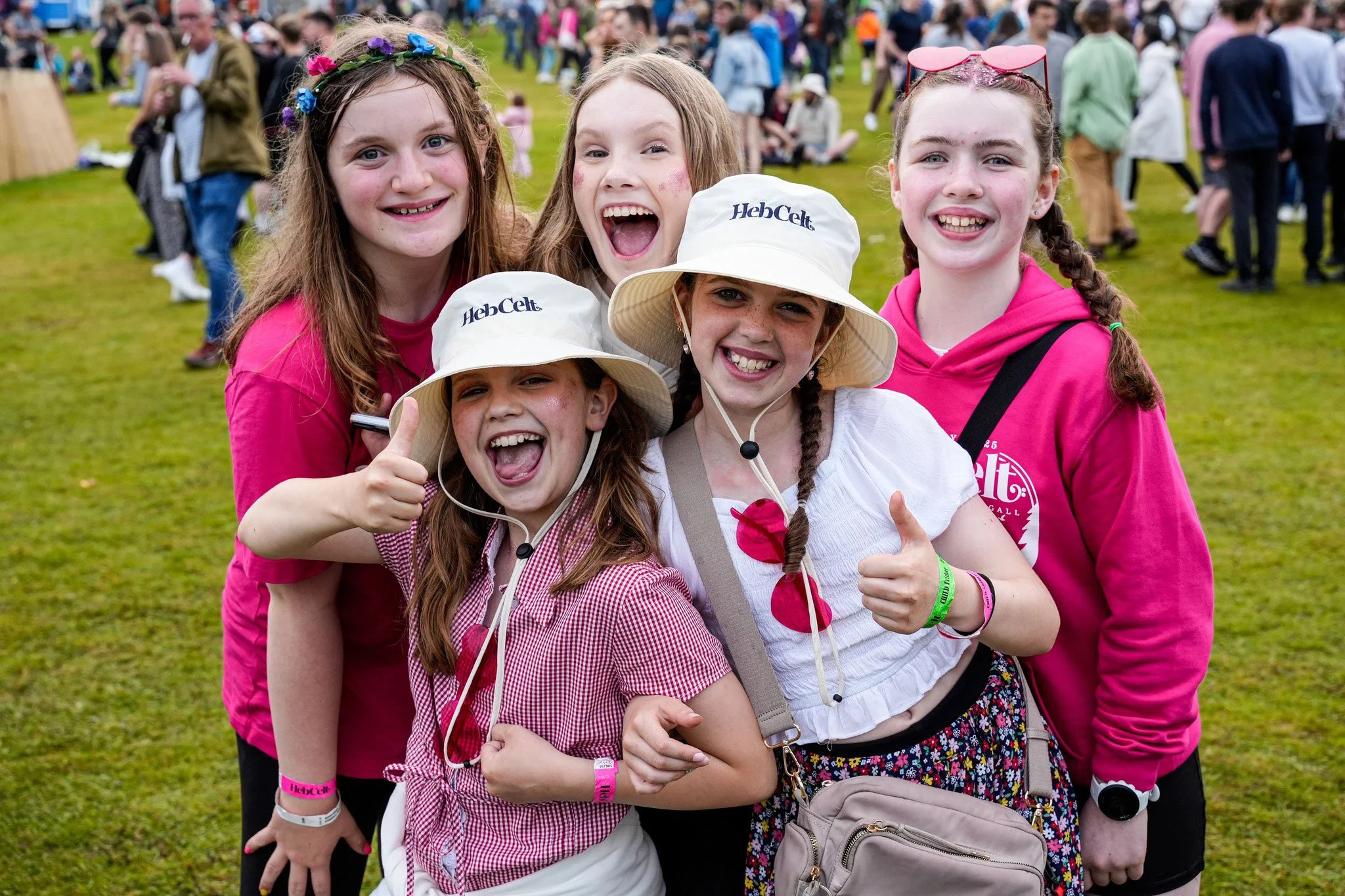 A bunch of young girls happy and smiling and enjoying the HebCelt festival in Stornoway in their branded merchandise