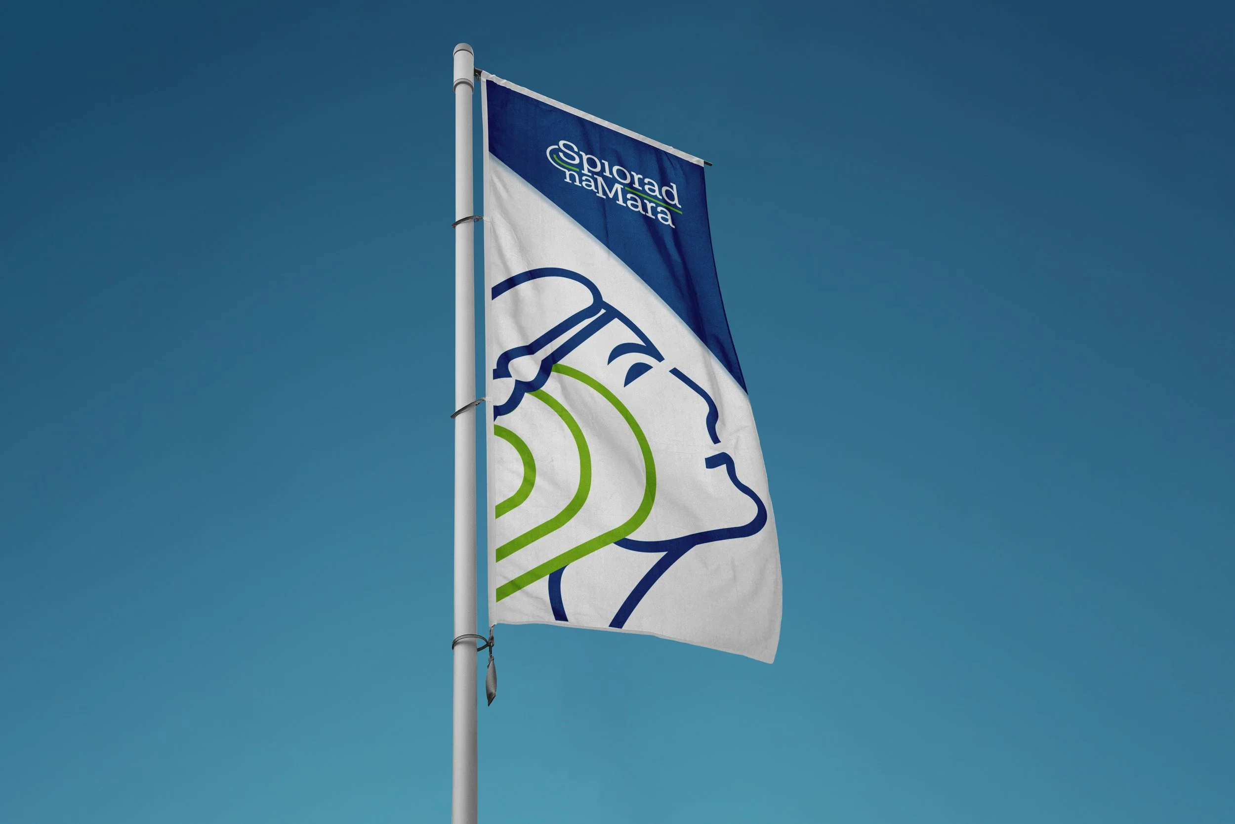 A flag with the logo and text for Spiroad naMara, flying against a clear blue sky.