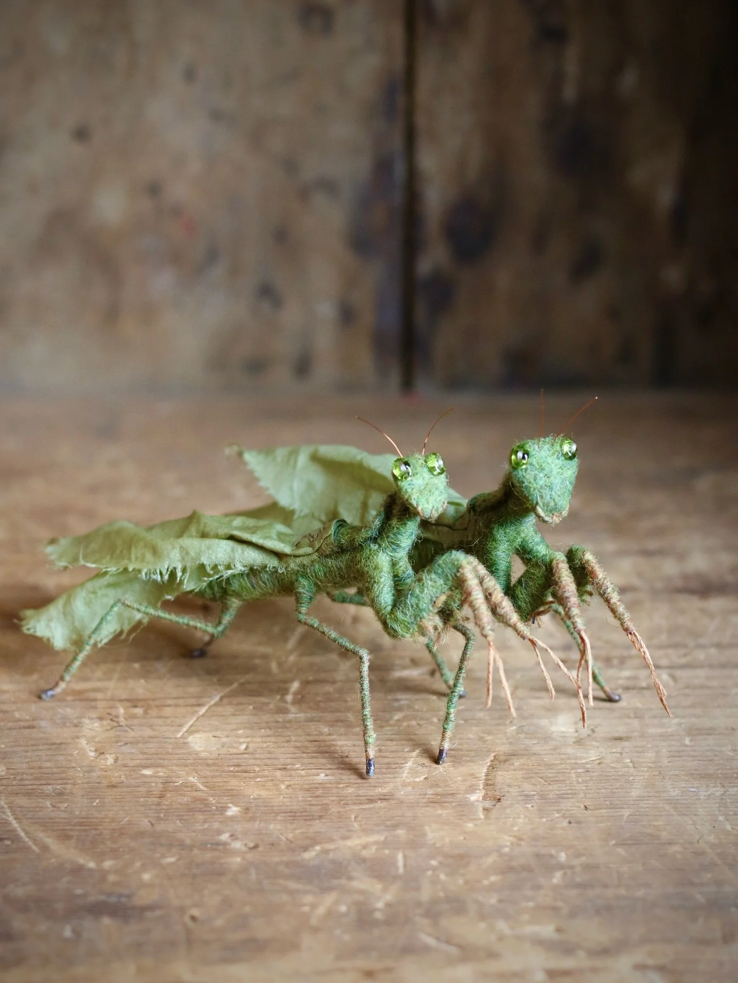 Two needle felted praying mantis made with wire, wool, silk, thread, glass beads, beeswax. Available now on my website. Link in profile. 💚