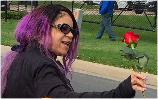 Tyka Nelson, holding a rose with her hairs colored in purple, to honor the memory of his lost brother
