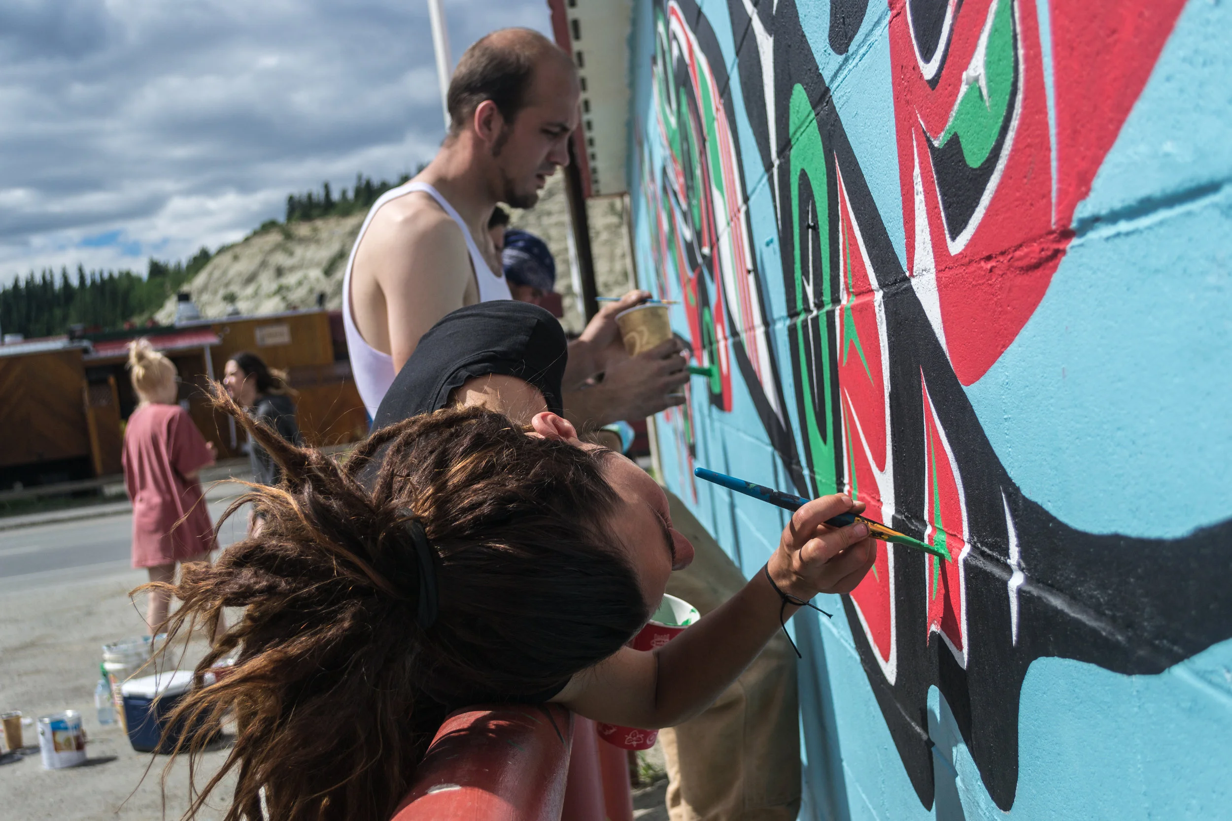 Indigenous and non-Indigenous artists work together to design and paint the murals on walls across Whitehorse.