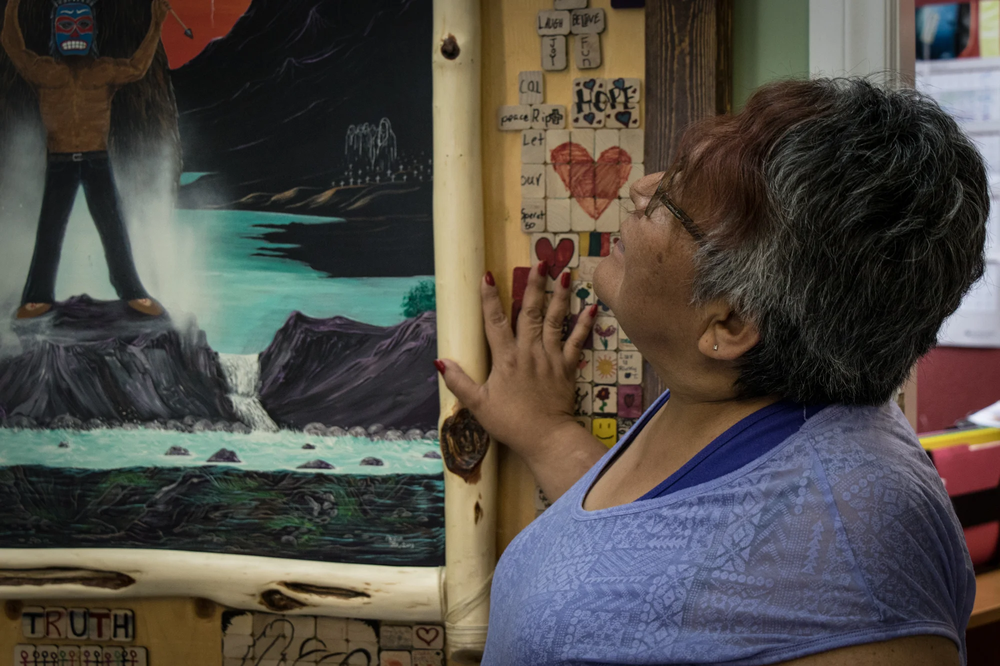 Healing is done through many ways. Here, Henry gazes up at a piece of art made by several members of different Indigenous communities.They find healing in creative collaboration, giving them a sense of community