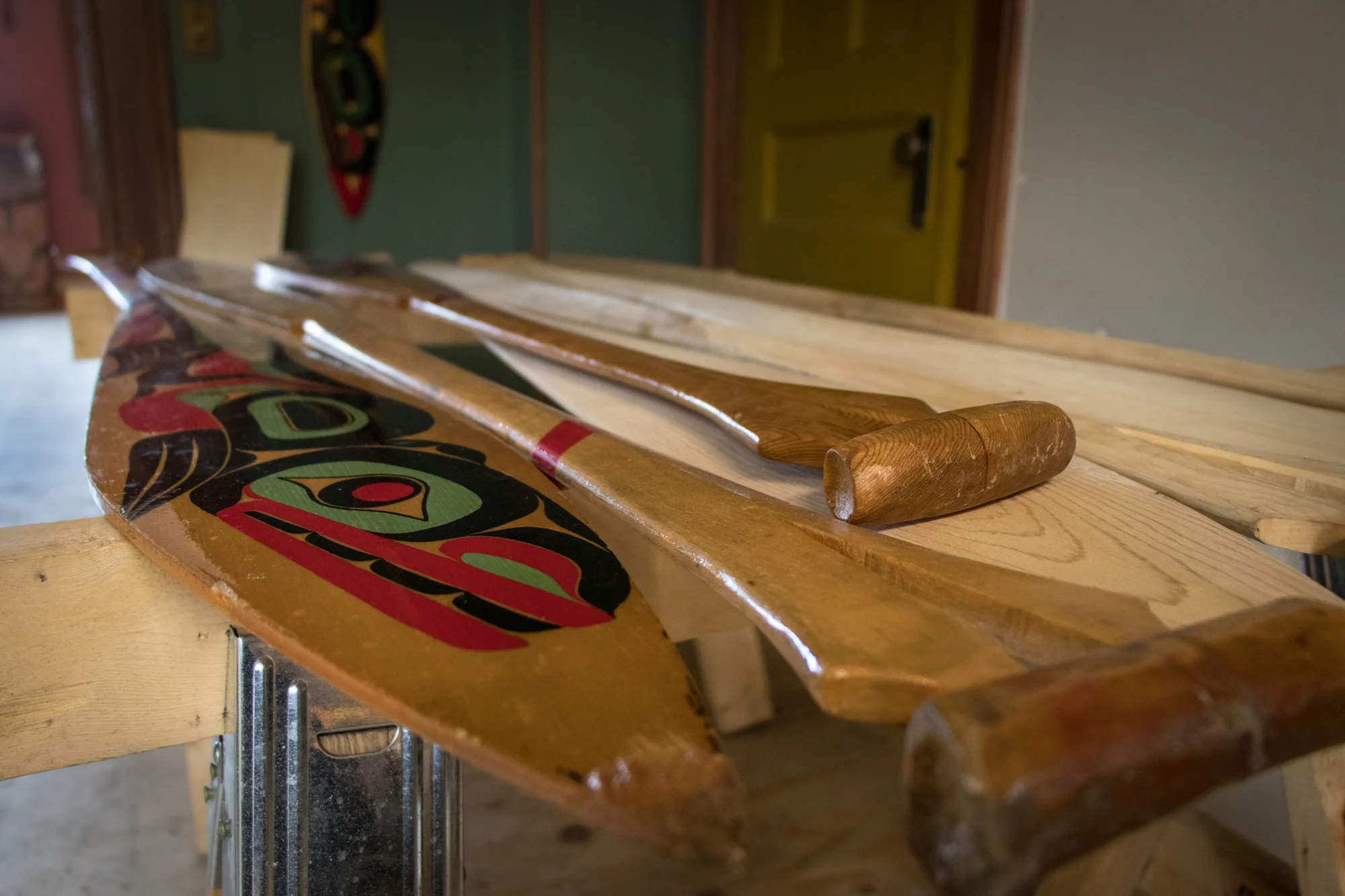 Once the paddles are carved, they are then decorated in traditional paintings and then preserved with varnish.