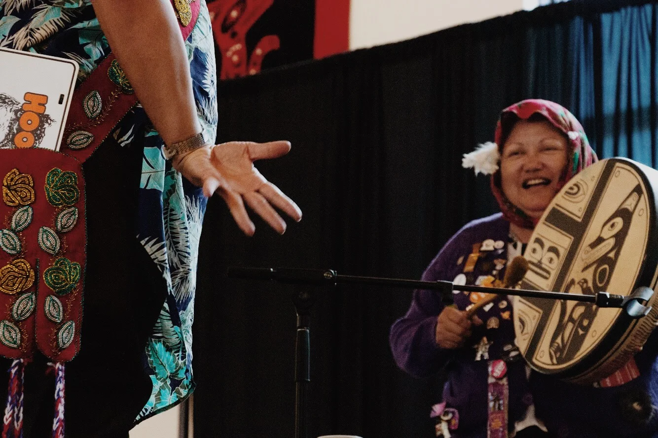 Shorty drums while Ghastant' Aucoin performs the grouse dance, a traditional Tlingit mating dance.