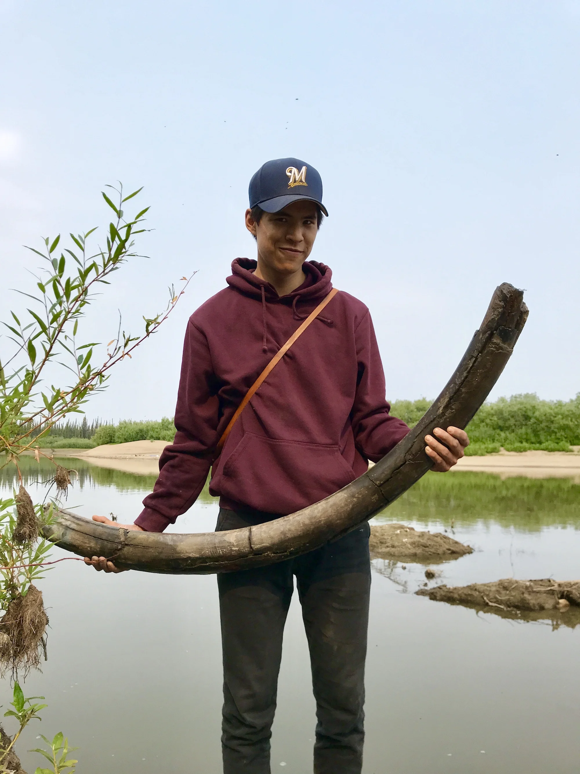 Caleb Charlie holds a mammoth tusk that was unearthed earlier in the day. (Photo: Sarah Williscraft)