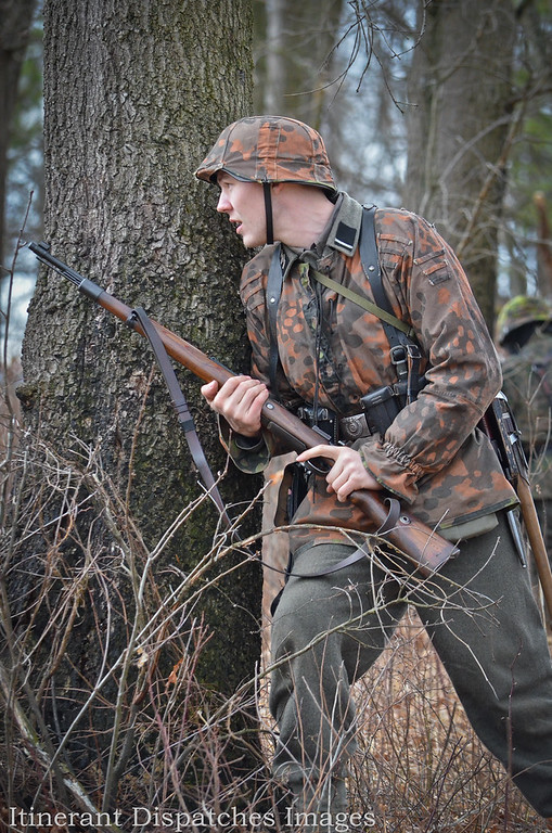 Sturmmann Pelz takes cover behind a tree.