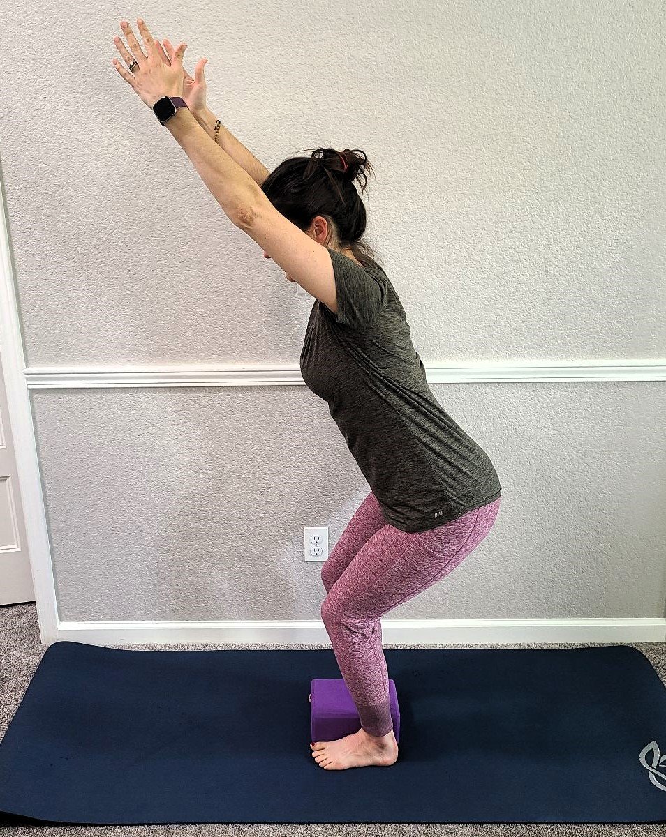 Chair pose with block between feet