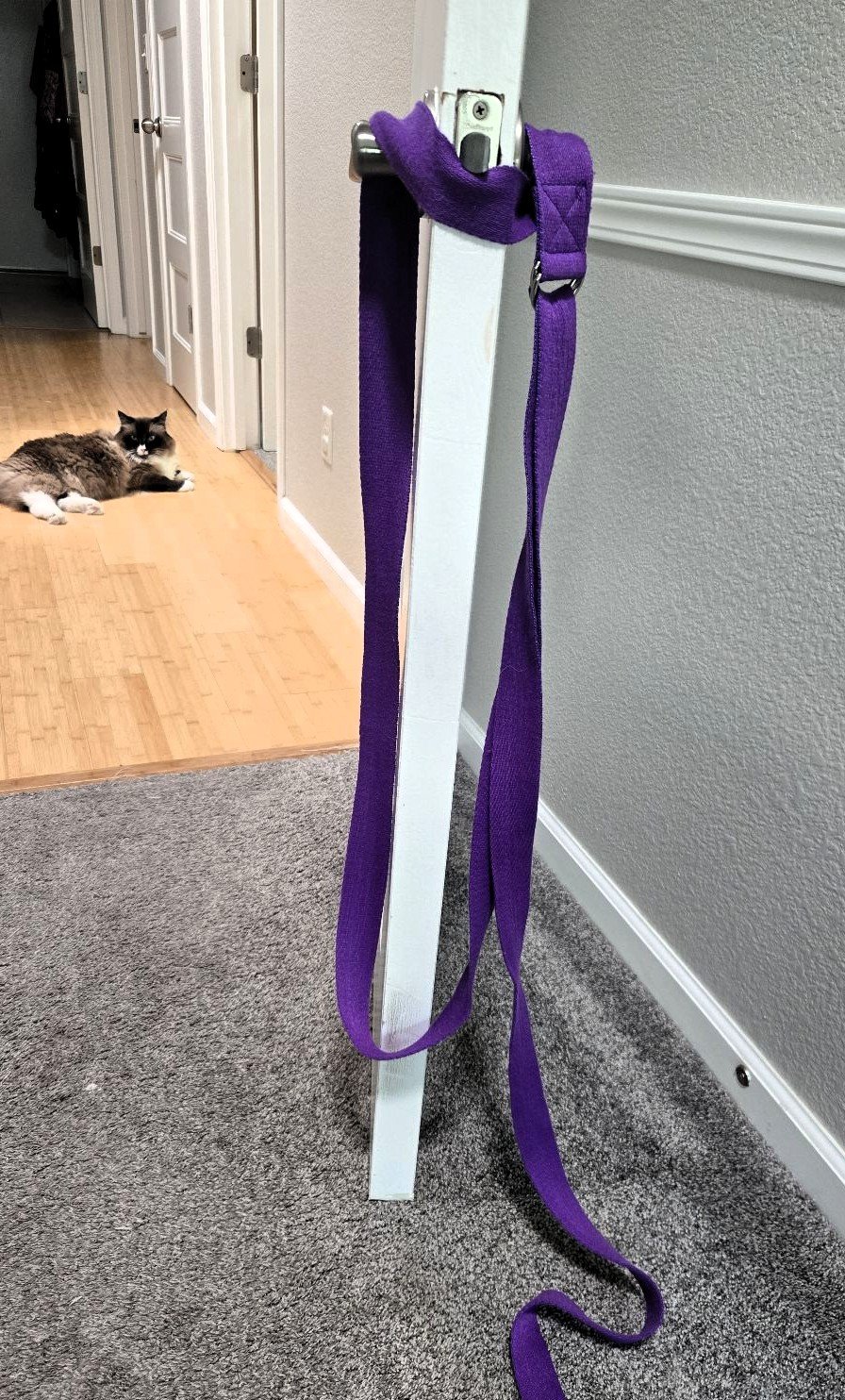 Looped yoga strap around door handles