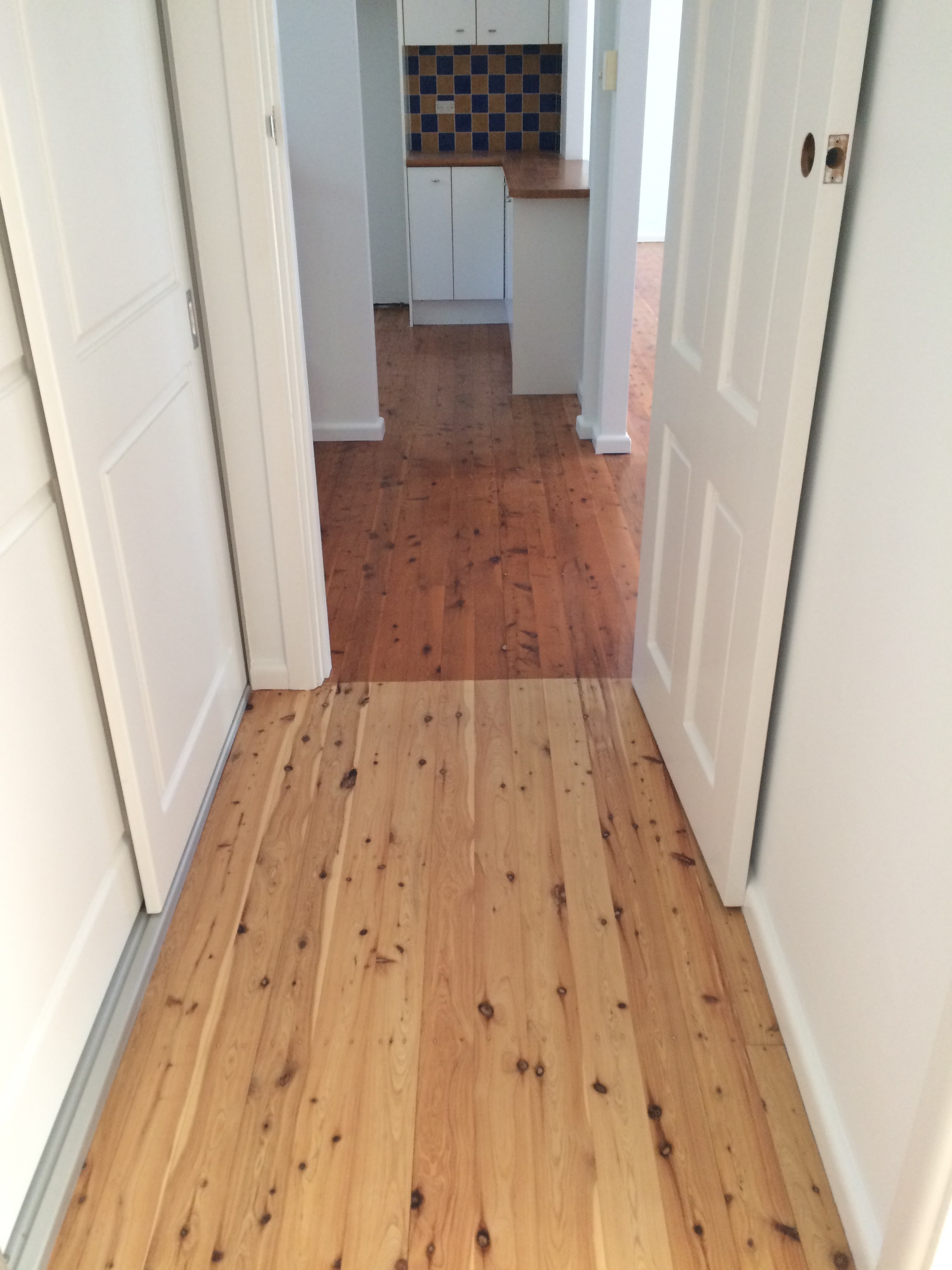 Here you can see the current transition from our bedroom wing hallway to the living and kitchen. What a difference removing that old oil-based polyurethane has made! Water-based all the way! Scary kitchen beyond to be renovated soon! 