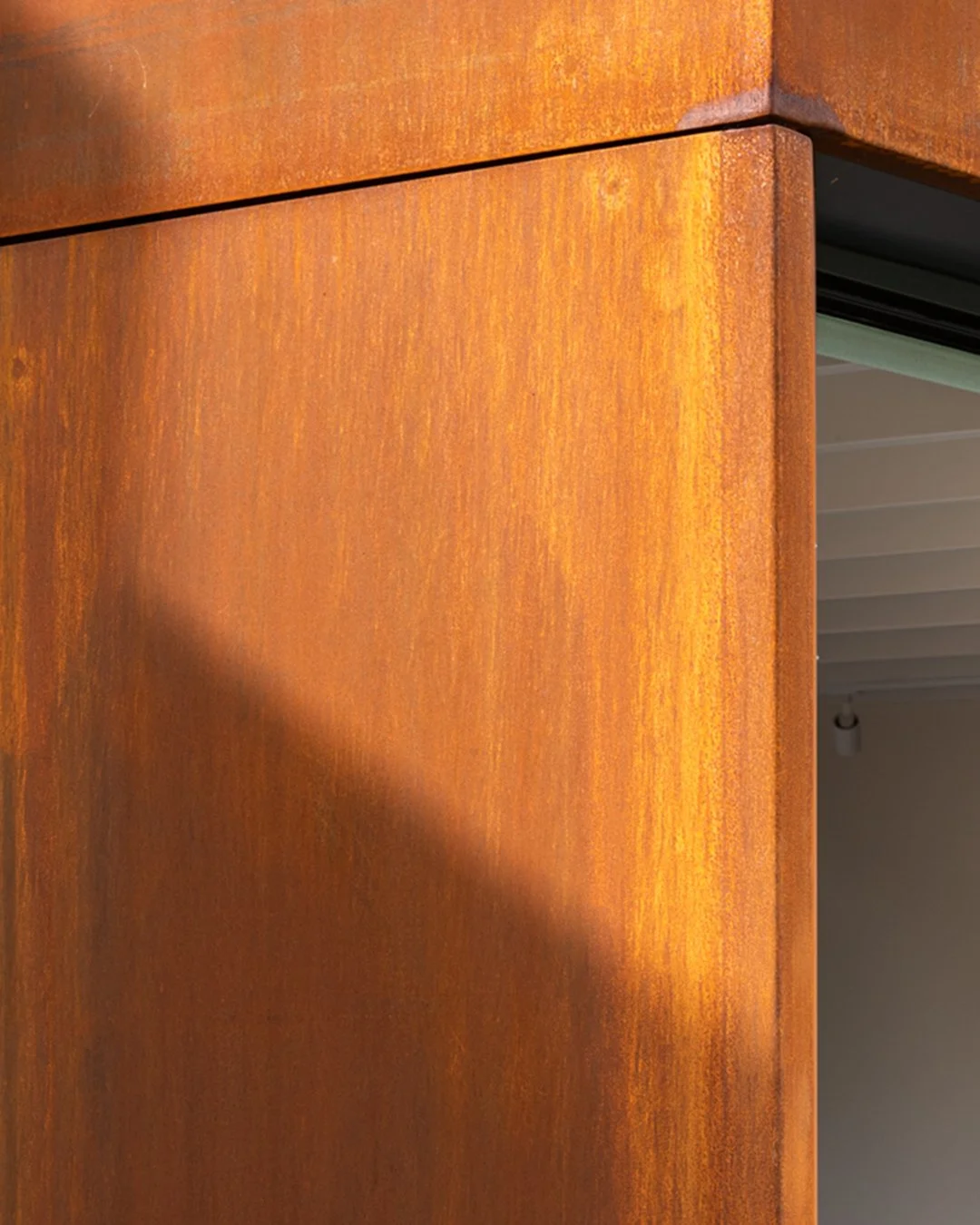 Close-up of a folded Corten steel corner reveal at a ground-floor opening, Lordship Lane.