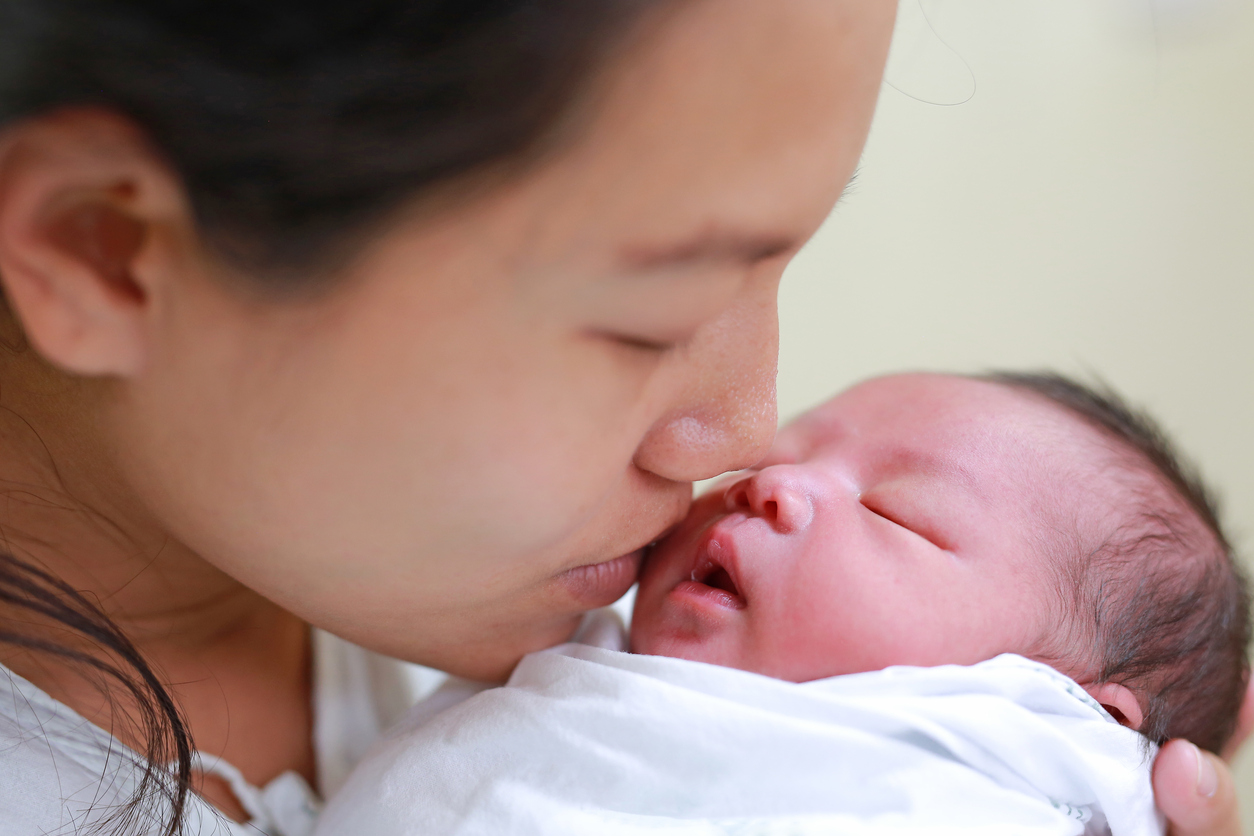 Mother-kissing-infant-baby-in-her-arms-in-hospital-after-delivery-room.-910344646_1258x838.jpeg