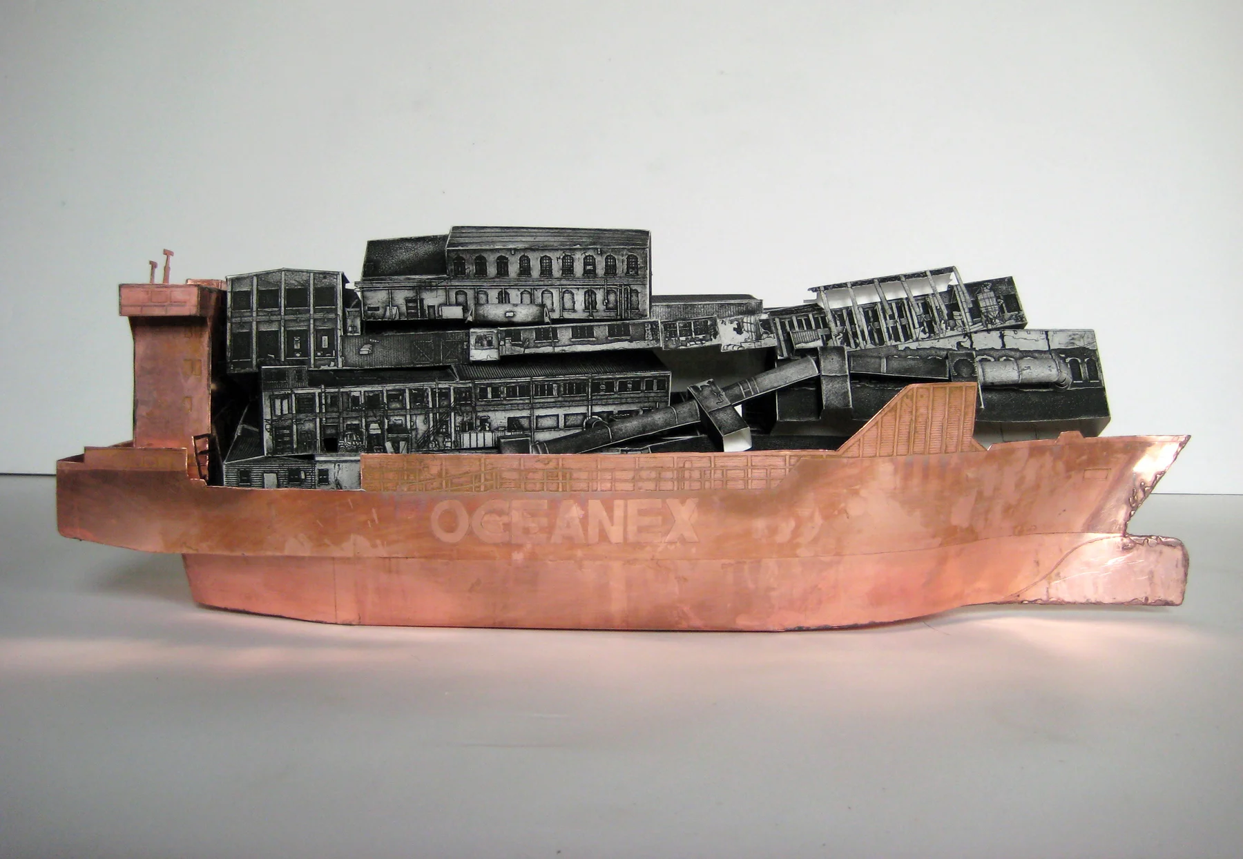 Oceanex Avalon (2009) Begun during a residency in St. John’s, Newfoundland, Oceanex Avalon enacts a ceremonial burial of industrial remnants. Using copper etching plates, I constructed a model of a cargo ship, the Oceanex Avalon , which was then filled with etched paper models depicting the region’s once-thriving fishing industry. This ship was set into a 200L bath of weak ferric chloride etching acid and left to slowly erode throughout the duration of the exhibition - destroyed by its own means of production. As it floated for nearly a month in this chemical bath, a mist gathered, lulling one into a belief that it might avoid the inevitable sinking - which occurred shortly before the exhibition closed. This act of burial-at-sea for these lost industries memorializes what was lost, while cautioning against the unchecked speculation that comes with a second boom. Oceanex Avalon was produced with the support of St. Michael's Printshop