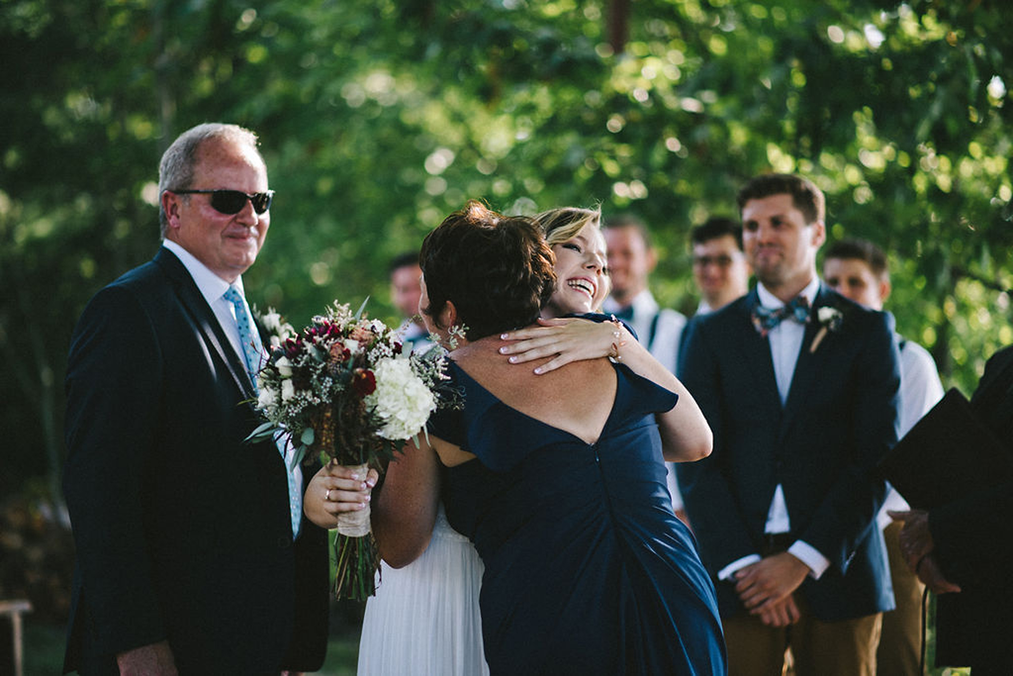 Bride hugging mother at lakeside Parry Sound camp wedding