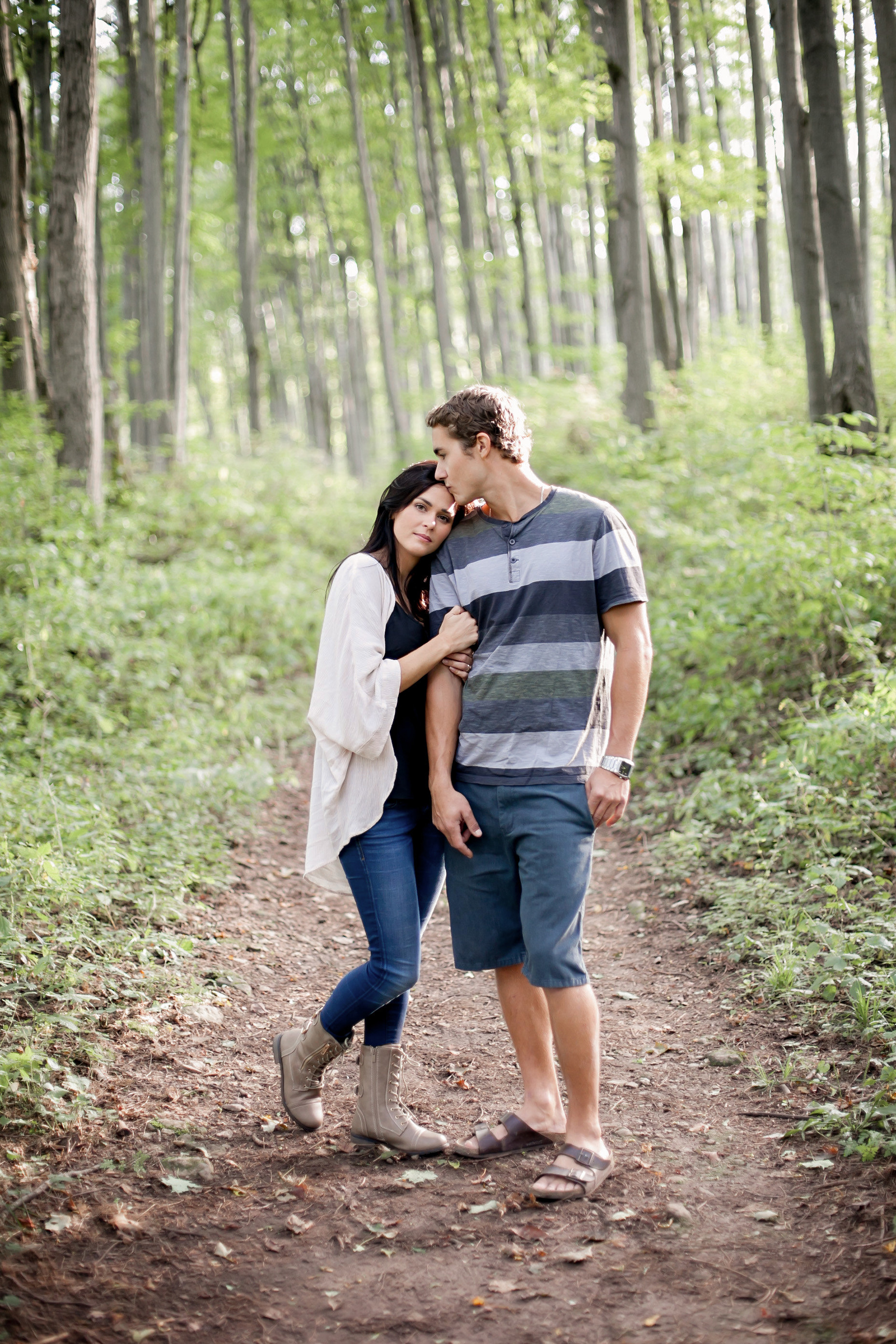 Newly engaged couple stroll through forest at Castle Glen Estate