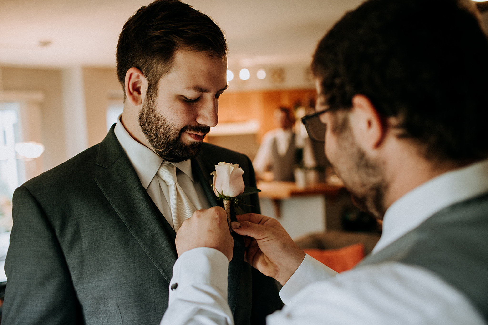 pinning a boutonniere on the groom at meaford barn wedding