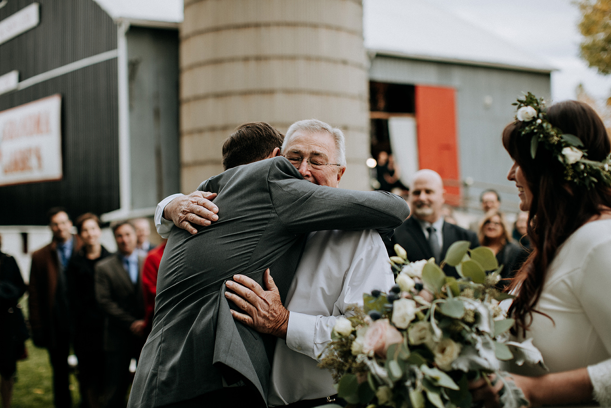 father of the bride welcomes groom into family at outdoor ceremo