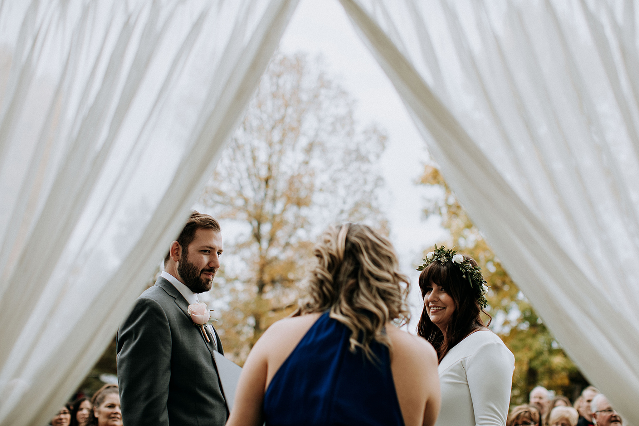 white flowing linens frame bride and groom during outdoor weddin